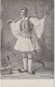 an old black and white photo of a man dressed in traditional hungarian garb holding a stick