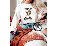 "Team Santa Sweatshirt, Matching Family Christmas Hoodies, Team Christmas Shirts, Group Christmas Sweatshirts, Christmas Squad All of our products are unisex. Please check the size guide in the images section to avoid disappointment. ❣️💌 📌 Carefully hand-printed using the latest technology printing houses and ink. 📌 Fits like a glove. No really, there's a new men's and women's Tee/Hoodie with a much more modern cut. 📌 Quality soft fabric. Feels like wearing it on a Saturday afternoon! HOW TO ORDER  ❤ Please Check and Review All Photos. ❤ Choose your Tee/Hoodie Style from the menu. ❤ Choose Your Piece As Much As You Want. ❤Click ADD TO CART. You can go back or complete the checkout to add more product colors and text colors for your family members. ❤Please click \"Continue Payment\"  MA Santa Sweatshirt, Hoodie Style, Saturday Afternoon, Christmas Hoodies, Family Events, Latest Technology, Personalized T Shirts, Christmas Sweatshirts, Christmas Tshirts