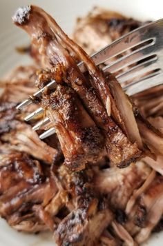 a fork is stuck into some meat on a plate