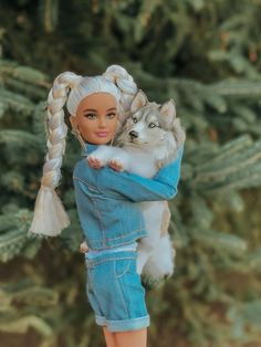 a barbie doll holding a white dog in her arms and wearing a denim outfit with braids