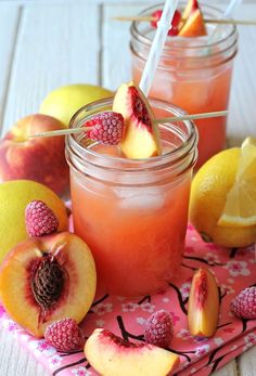 two mason jars filled with peaches and raspberries