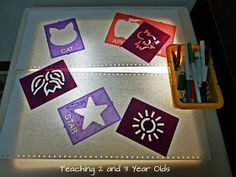 a lit up table with some writing and pictures on the top, next to markers and pencils