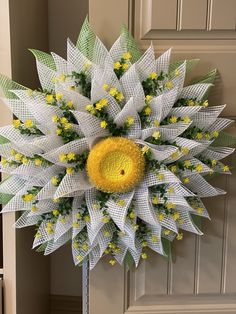 a large white and yellow wreath on the front door