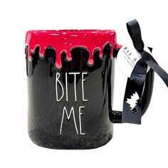 a black and red coffee mug with the words bite me painted on it's side