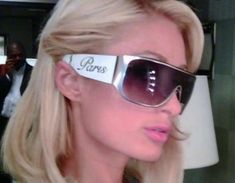 a blonde woman wearing sunglasses with the word i love paris written on her side in front of her face