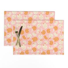 two pieces of pink and orange patterned paper with scissors on top of each piece,