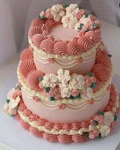 three tiered cake with pink frosting and white flowers