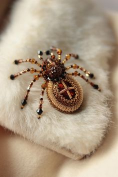 a spider brooch sitting on top of a white fur