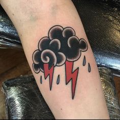 a black and red cloud with lightning bolt tattoo on the left arm, by person