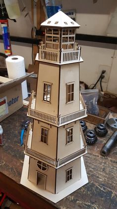 a model of a tall building on top of a wooden table next to some tools