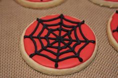 cookies decorated with icing and spider webs on a baking sheet