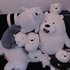 a group of stuffed animals sitting next to each other on top of a black couch