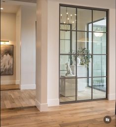 an empty room with large glass doors and wooden floors