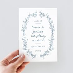 a hand holding up a wedding card