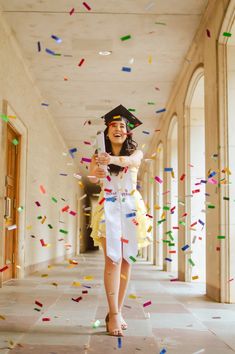 a woman in a graduation gown is throwing confetti