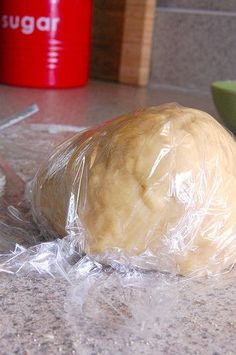 a doughnut wrapped in plastic sitting on top of a counter