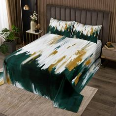 a bed with green and white paint on the sheets, pillows and pillowcases