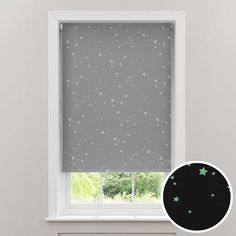 a grey roller blind with silver stars on it and a white window sill in the background