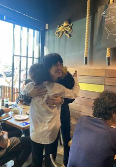 two women hugging each other in a restaurant