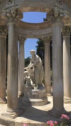 the statue is surrounded by pillars and flowers