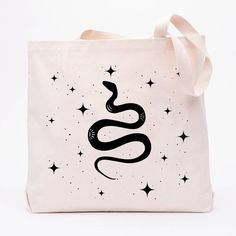 "The Mystical Snake Canvas Tote is the perfect bag to take with you everywhere! Whether you are going to the grocery store, carrying your gym clothes, or needing an overnight bag for a short getaway, this tote has got your back. Handmade with care in the U.S., this canvas tote features a 12oz. 100% cotton twill fabric and Cotton web handles that make it super sturdy and durable for all your daily activities. Plus, its eye-catching \"Mystical Snake\" print makes it a real showstopper! Make a stat Making People Happy, Plastic Grocery Bags, Grocery Tote, Grocery Bags, Hand Screen Printed, Denver Co, Reusable Bags, Overnight Bag, Cotton Twill Fabric