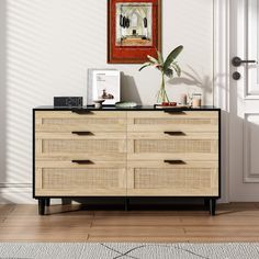 a wooden dresser sitting in front of a door with a painting on the wall above it