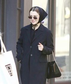 a woman walking down the street carrying shopping bags