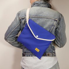 MUSETTE WITH TRIANGLE FLAP La Jefa's bag of tricks; portable, foldable, affordable, formidable. Made of strong water resistant canvas in royal blue Features: -water-resistant -inside pockets -snap button closure -adjustable strap -key strap -reflective detail -additional stabilizer strap -folds and fits in a pocket Size: W: 30 cm (11.8 in) H: 27 cm (10.6 in) Shoulder strap length (approximately): min: 60 cm (23.6 in) max: 111 cm (43.7 in) Feel free to see other models of musettes: https://www.et Streetwear Bags, Musette Bag, Cycling Bag, Walking In The Rain, Bike Bag, Bicycle Accessories, Everyday Bag, Unique Charms, Cotton Bag