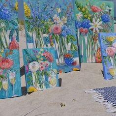 paintings on the beach with flowers in vases