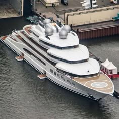 an aerial view of a large white boat in the water near a dock and buildings