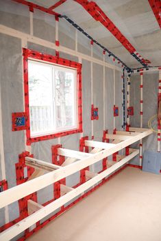 an unfinished room with red and white tape on the walls, windows and shelves in place