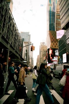 people crossing the street at an intersection in new york city