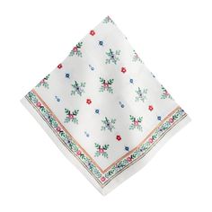 a white napkin with red, blue and green floral designs on it's edges