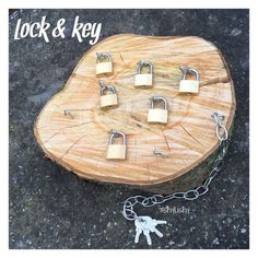 four padlocks are attached to a chain on top of a wooden slab with the words lock and key written below them