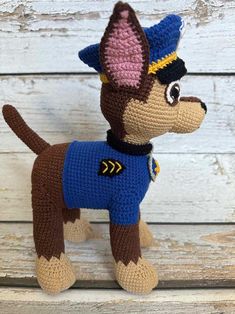 a crocheted stuffed dog wearing a blue shirt