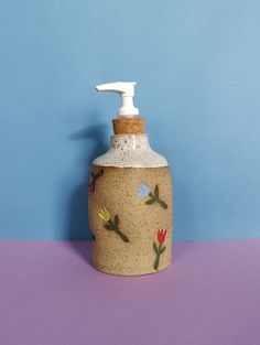 a soap dispenser sitting on top of a purple table