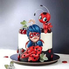 a lady bug themed cake is sitting on a table