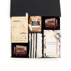 an assortment of coffee and teas in a black gift box on a white background