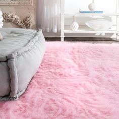 a pink shaggy rug on the floor in a living room