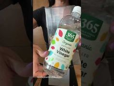 a woman holding a bottle of white vinegar in her left hand and an image of the bottle with colored dots on it