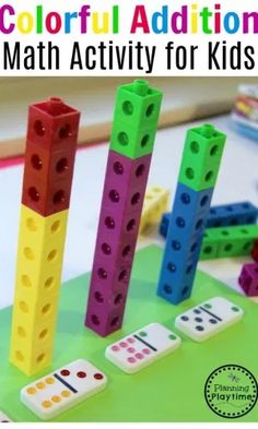 four lego blocks with numbers on them sitting on a table next to dices and pencils