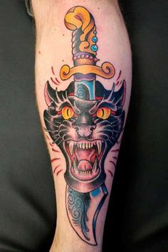 a man with a tattoo on his leg and an angry cat head in the middle