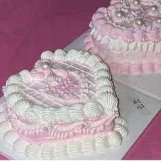 two cakes with pink frosting and pearls on them