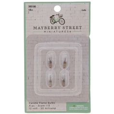 three miniature candles in plastic packaging on a white brick wall with the words mayberry street miniatures