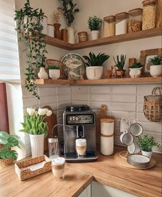 a coffee maker sitting on top of a wooden counter next to potted plants and other items