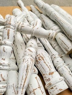 a pile of white wooden sticks sitting on top of a cardboard box next to each other