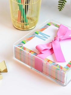 a box with a pink bow on it next to a gold cup and other items