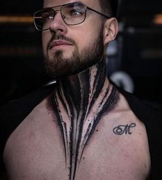 a man with tattoos on his chest and neck is looking at the camera while wearing glasses