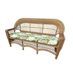 a wicker couch with green and pink flowers on the seat cushion is sitting against a white background