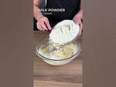 a woman mixing ingredients in a bowl on top of a wooden table with the words milk powder